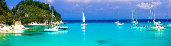 Beautiful turquoise bay Lakka in Paxos with sailing boats. Ionian islands of Greece