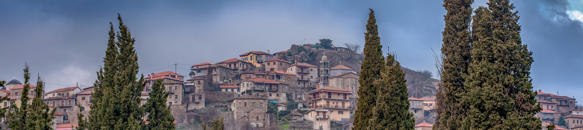 Panoramic view of a beautiful mountain village named Dimitsana under a dramatic sky and fog, Peloponesse, Greece